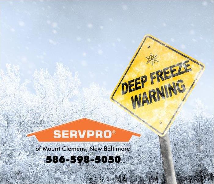 A yellow, diamond-shaped sign stating, “Deep Freeze Warning” is show against a snowing backdrop, 